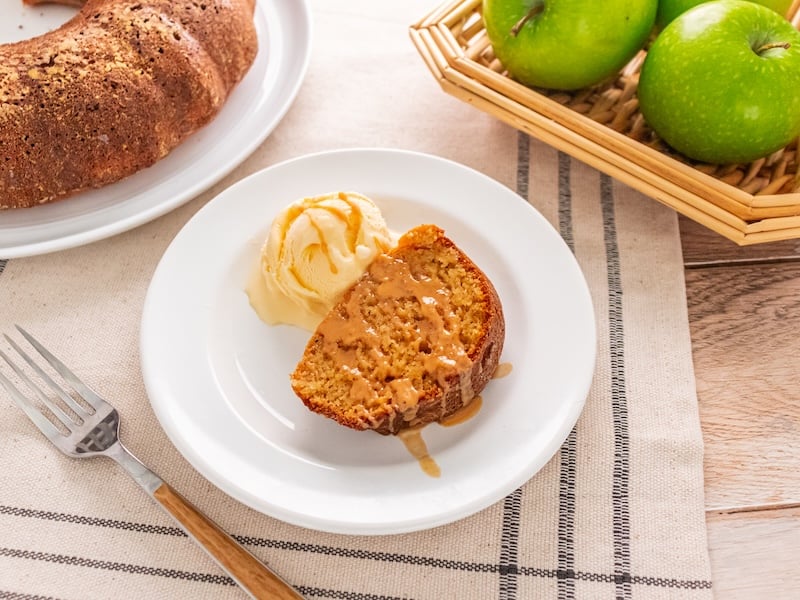 This moist Paleo Apple Cider Bundt Cake features warm fall spices, a creamy caramel apple glaze, and a scoop of vanilla ice cream.