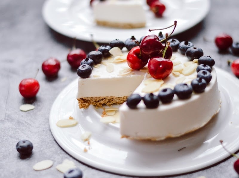 No-bake paleo cheesecake made with Paleovalley bone broth protein, topped with blueberries, cherries, and sliced almonds.
