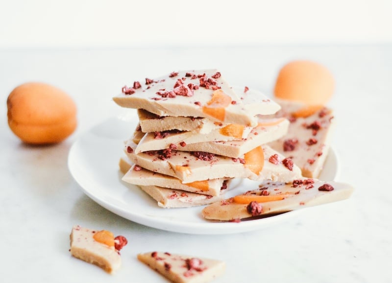 Collagen coconut bark made with bone broth protein powder, topped with dried apricot slices and freeze-dried berries.